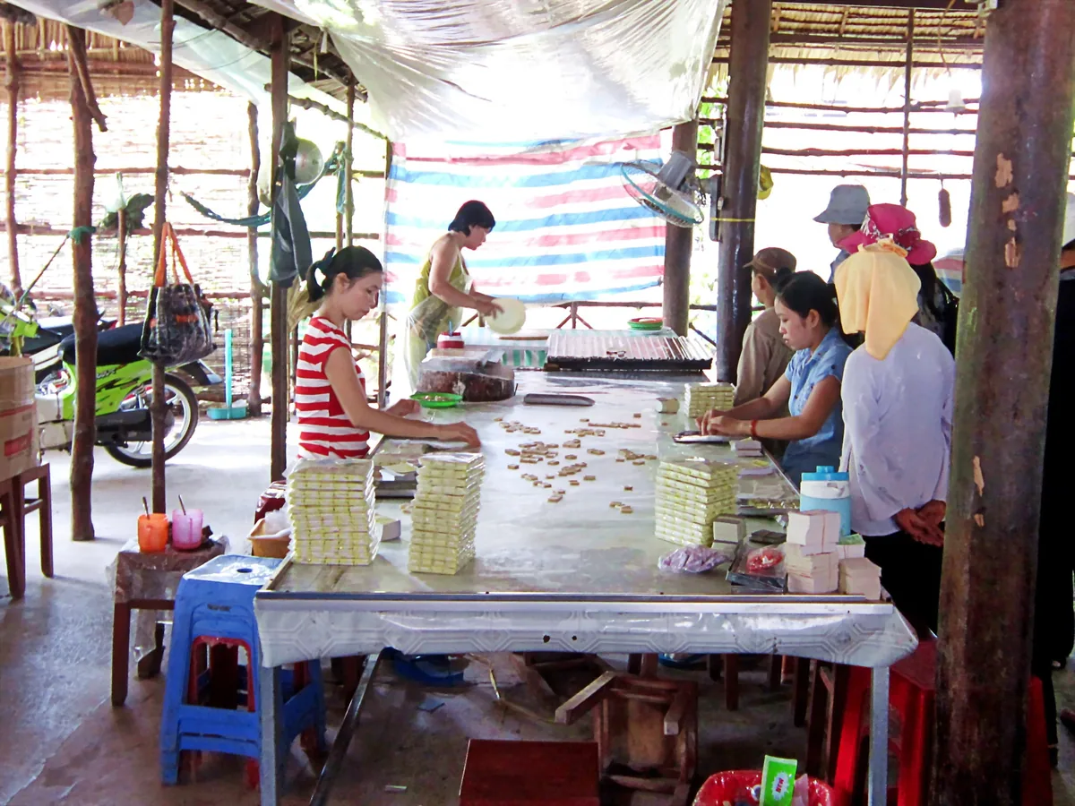 Những người thợ làm và đóng gói kẹo dừa tại một cơ sở sản xuất mở ở Đồng bằng sông Cửu Long.